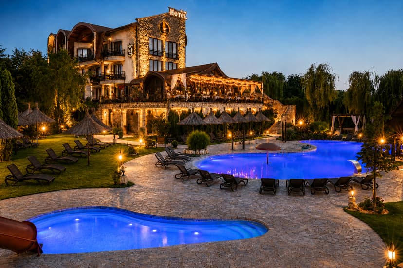 Castel Transilvania Baia Mare cu piscine exterioare și clădire iluminată