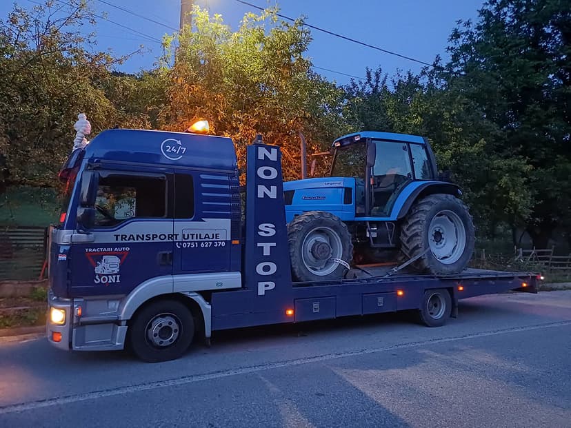 Platformă Tractări Auto Baia Mare – Joni transportând un tractor pe drum
