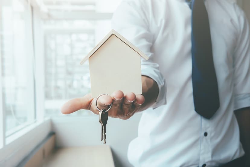 Imobiliare în Baia Mare, Maramureș – agent care oferă o casă simbolică și cheile unei proprietăți.